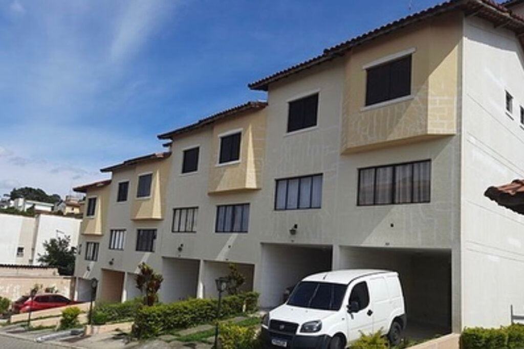 As mesmas casas antes da obra, com a pintura bege manchada.